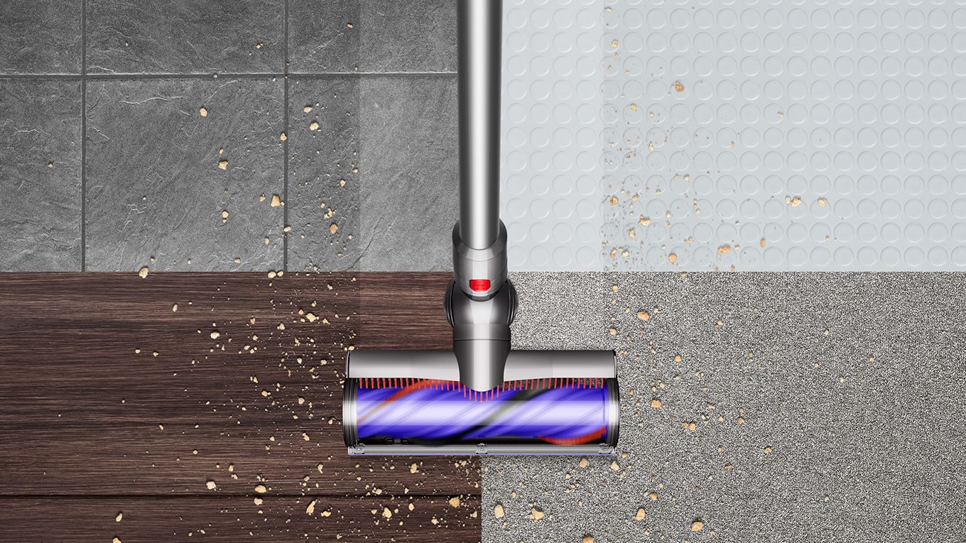 Overhead view of the Dyson V8 vacuum cleaning debris from hard floor and carpet.
